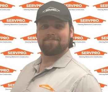 SERVPRO employee in front of a SERVPRO background.